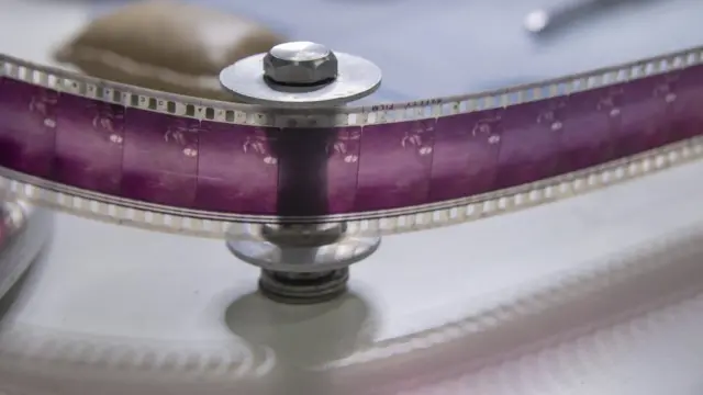 ใช้มือหมุน ค่อย ๆ ตรวจฟิล์มเป็นเฟรม