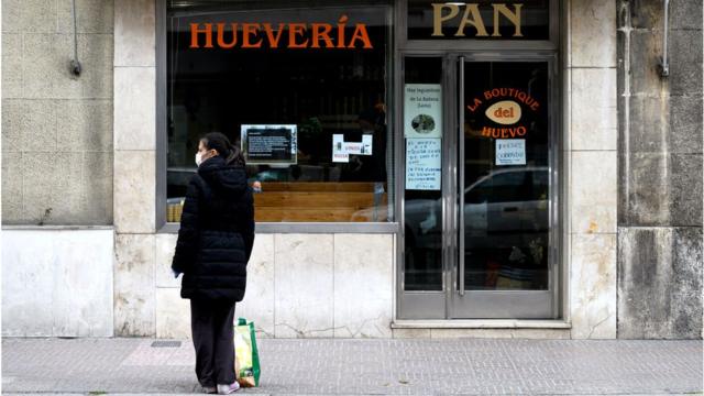 Жінка біля зачиненого магазину в іспанському Бургосі 31 березня 2020 року