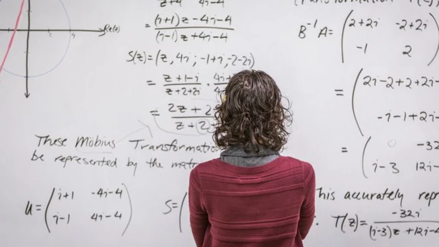 Mulher olhando para fórmulas matemáticas