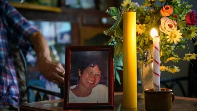 Una fotografía de la esposa de Aclo, rodeada de velas y flores