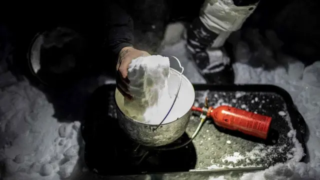 Французский солдат растапливает снег на учениях