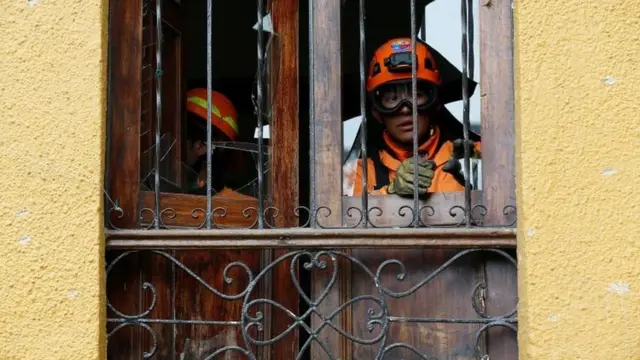 Bomberos en las ventanas dañadas tras la explosión.