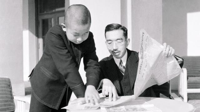 Emperor Hirohito and Prince Akihito reading a newspaper