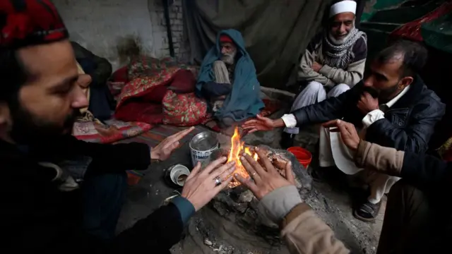 People sit around a fire to beat the cold weather in Peshawar, Pakistan, 04 January 2017. EPA/ARSHAD ARBAB