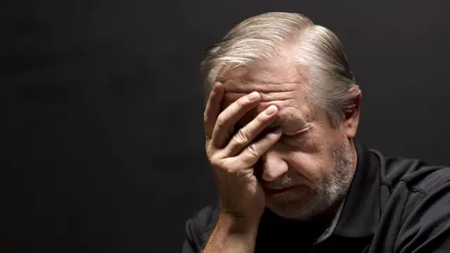 Un hombre se toma la cabeza.