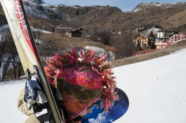 متزلج يرتدي قبعة متوجها نحو المضمار.