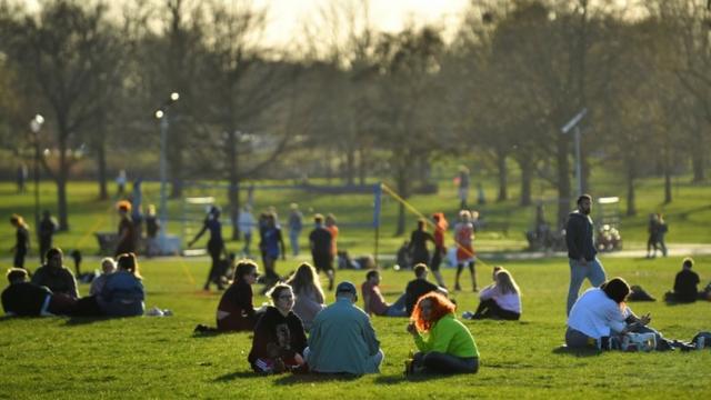Grupo de personas se reúnen en un parque de Londres.