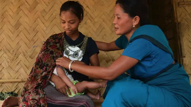 An accredited health worker explains the benefit of breastfeeding a baby to a mother from the Reang Tribe at her bamboo hut in Birendranagar Village, Jolaibari, Agartala, India.
