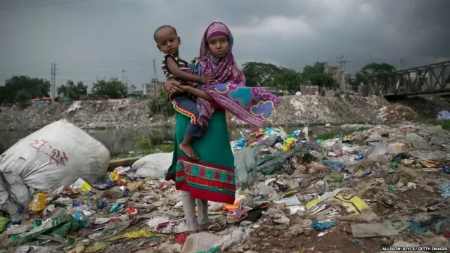 ਬੁੜੀਗੰਗਾ ਨਦੀ ਦੇ ਕਿਨਾਰੇ ਇੱਕ ਪਾਲਸਟਿਕ ਫੈਕਟਰੀ ਦੇ ਬਾਹਰ ਖੜ੍ਹੀ ਇੱਕ ਲੜਕੀ।