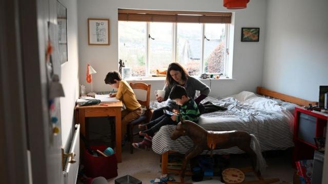 Una madre con dos hijos dentro de una habitación