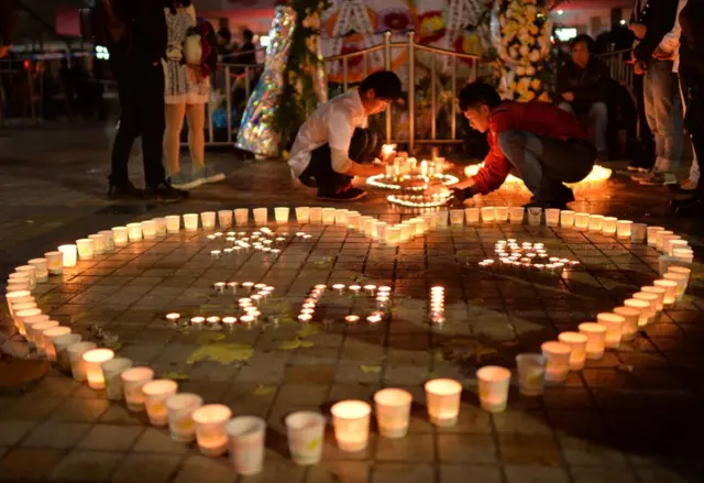 雲南省の鉄道駅でおきた刃物による襲撃事件の犠牲者を追悼しろうそくが並べられた（14年3月）