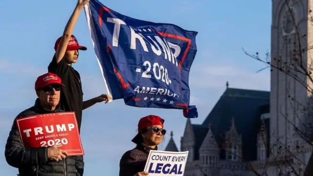 Manifestantes seguram cartazes pró-Trump