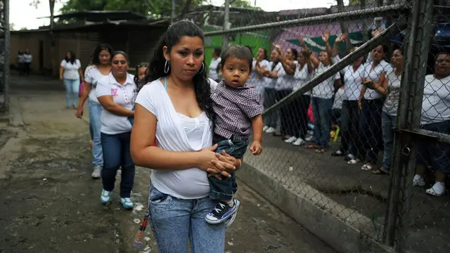 Una madre con su hijo en brazos en una prisión