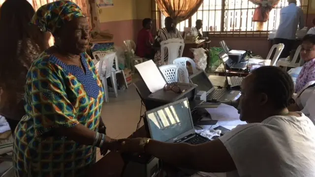 Elderly woman wey dey do her registration