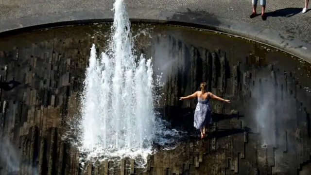 One woman dey cool off for one water fountain for Berlin, Germany