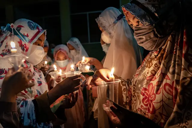 MAY 02: Students wear protective masks light candles as they prepare for read the Quran during ritual Nuzulul Quran and Laylat al-Qadr (Night of Destiny) which marks the night in which the holy Quran was first revealed to the Prophet Mohammed at the Nurul Hidayah Al-Mubarokah boarding school on May 2, 2021 in Boyolali, Central Java, Indonesia. Laylat al-Qadr is was one of the odd-numbered nights of the last ten days of Ramadan. Millions of Muslims around the world fasting from dawn to dusk for a month. Ramadan, the ninth month of the Islamic calendar is a month of fasting, prayers and recitation of the Quran. (Photo by Ulet Ifansasti/Getty Images)