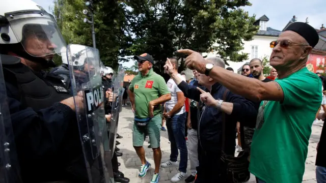 Demonstrators shout at riot police during one protest against enthronement of Bishop Joanikije for Cetinje