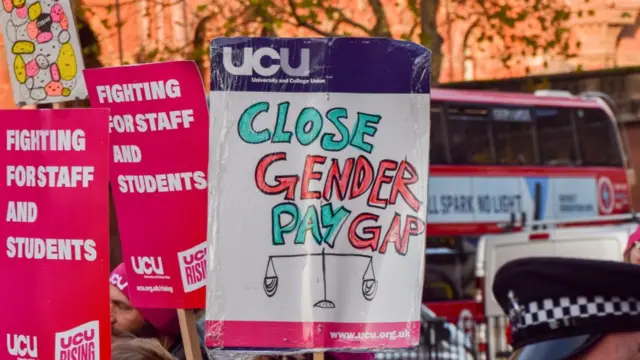A placard stating 'Close the gender pay gap' is seen during the march in Euston Road, London, in this Nov. 30, 2022 photo.
