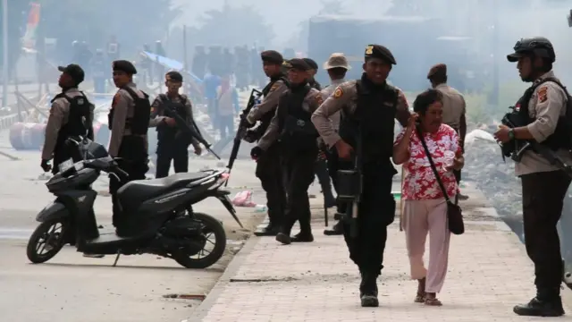 Petugas kepolisian mengevakuasi seorang warga saat melakukan penjagaan aksi
