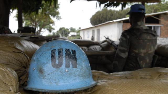 Casque de l'ONU à côté d'un soldat