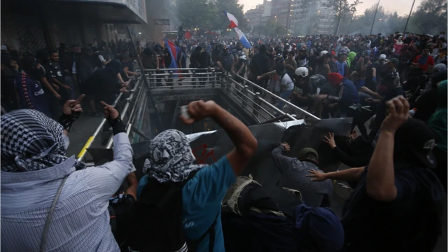 Pessoas jogando pedras durante protesto