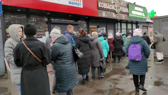 Des personnes font la queue dans une pharmacie locale, à Kiev, capitale de l'Ukraine.