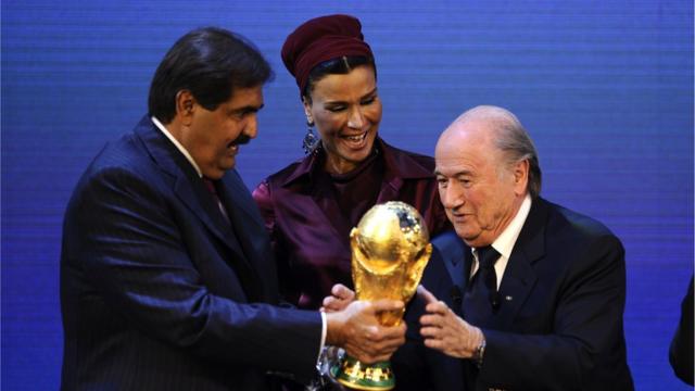 أمير قطر السابق وزوجته ورئيس الفيفا السابق يمسكون مع بكأس العالم بعد إعلان فوز الدوحة بتنظيم بطولة 2022