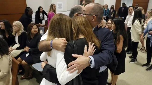 Varias personas se abrazan en la audiencia