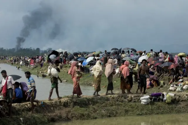 మయన్మార్‌లోని తమ గ్రామం దగ్ధమవుతుండగా వలసబాట పట్టిన రోహింగ్యా ముస్లింలు