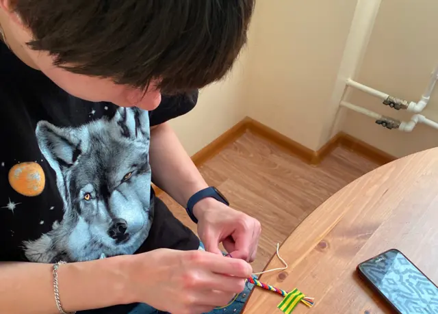 Nina tissant un bracelet d'amitié