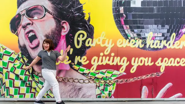 पोस्टर के सामने महिला