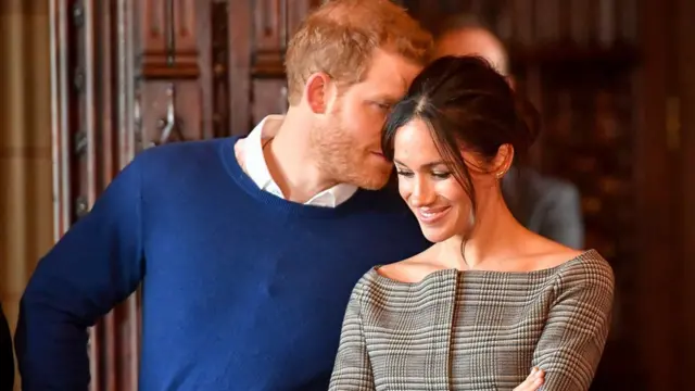 ميغان وهي تستمع للأمير هاري