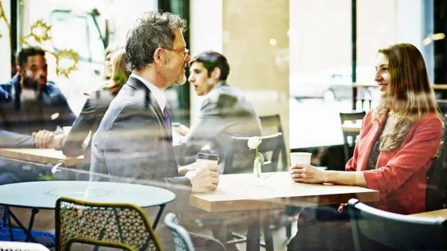 Un hombre y una mujer conversan en un café