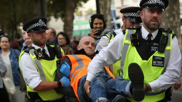 Двое полицейских уносят демонстранта