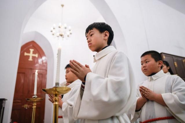 2018年12月24日，年轻的基督教徒在北京一所教堂参加弥撒。