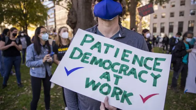 Chico con un cartel en el que pide paciancia