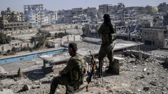 Raqqa vayronalariga qarab turgan Suriya Ozod armiyasi jangchilari