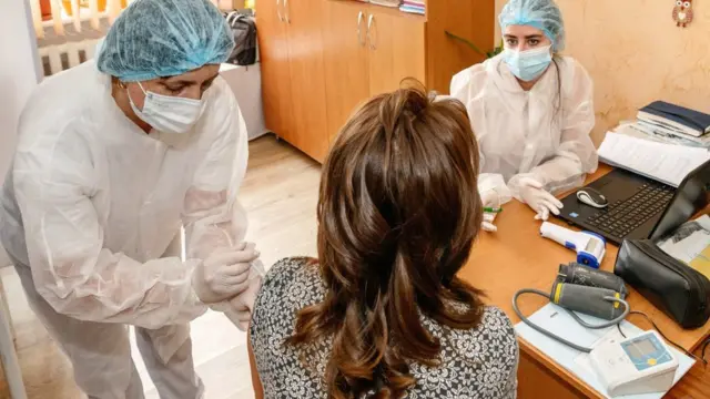 Медсестра делает прививку учительнице