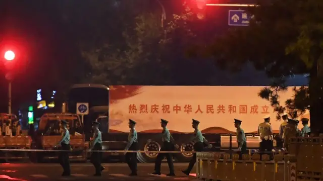 一队军人从庆祝标语前走过