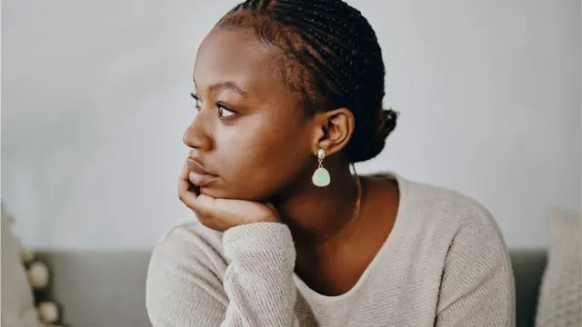 femme qui regarde au loin l'air triste