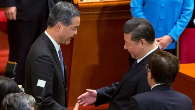 Chinese President Xi Jinping, right, shakes hands with Hong Kong Chief Executive CY Leung after Leung's appointment as a vice chairman of the Chinese People's Political Consultative Conference (CPPCC) on Monday, March 13, 2017.