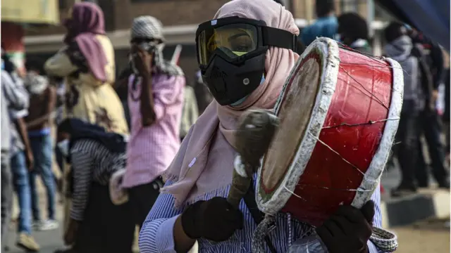 متظاهرة تقرع طبلة