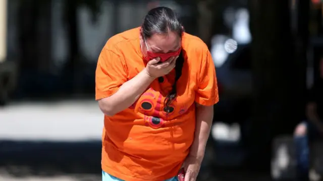 Una mujer llora frente a una vigilia en Canadá