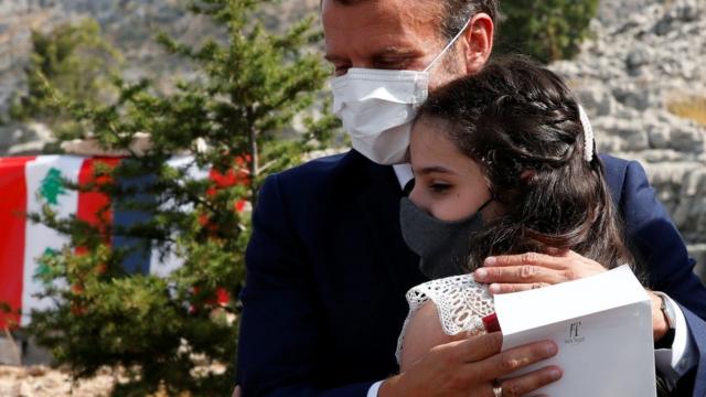 French President Emmanuel Macron hugs a victim of the Beirut blast after planting a cedar tree in Jaj, Lebanon (1 September 2020)