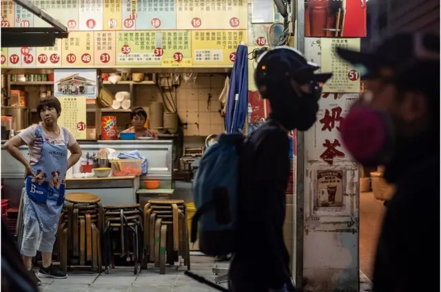 示威者走过一家湾仔街头没有生意的食肆。