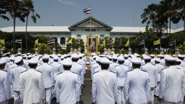 Bangkok officials standing in front of a portrait of Thai King Maha Vajiralongkorn Bodindradebayavarangkun