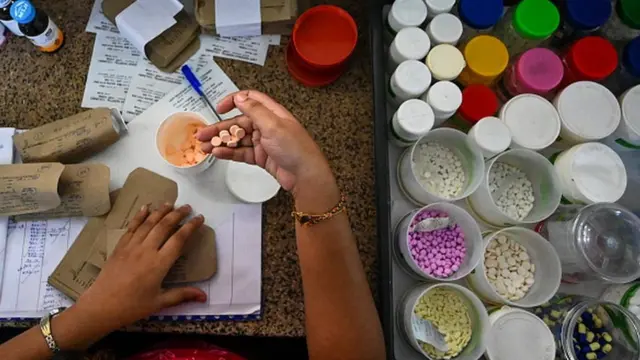 In this picture taken on April 21, 2022, a health worker packs medicines in Lady Ridgeway Hospital for Children in Colombo. - Sri Lanka used to import around 85 percent of its pharmaceutical supplies but is suffering its worst economic crisis since 1948.