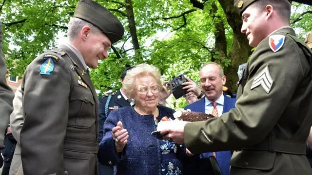 Sargento Wallis (à dir.) e coronel Gomlak (à esq.) seguram bolo para Meri Mion