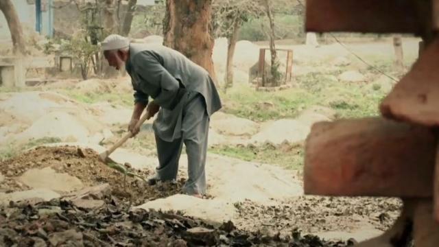 Mohammad Shareef levelling a grave