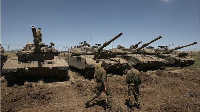 Soldados israelíes frente a tanques Merkava en los ocupados Altos de Golán